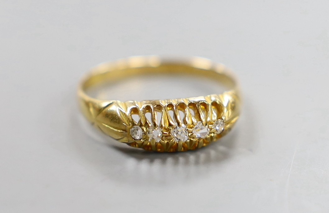 An early 20th century 18ct gold and graduated five stone diamond chip set half hoop ring, size Q, gross weight 3.2 grams.